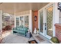 Inviting porch with a green bench, glass doors, and brick accents, creating a cozy entry at 9526 E Lake Ave, Greenwood Village, CO 80111