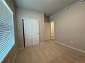 Bright bedroom featuring a double-door closet, large window with blinds, and neutral carpeting at 48245 Shetland Dr, Bennett, CO 80102