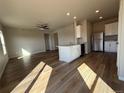 Open-concept kitchen featuring white cabinetry, stainless steel appliances, and eat-in island at 48245 Shetland Dr, Bennett, CO 80102