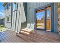 Stylish front entry with stained wood door, a wooden deck and a peek at the exterior of the house at 6388 Donner Cir, Parker, CO 80134