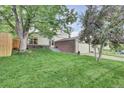 A charming home exterior showcasing a well-manicured lawn and tasteful brick accents at 4483 S Eagle Cir, Aurora, CO 80015