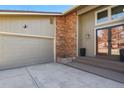 Close-up of the front entry and garage with a brick accent and modern lighting at 6866 W David Ave, Littleton, CO 80128