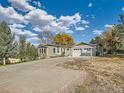 Exterior of house with inviting driveway and mature trees at 8700 Flintwood Rd, Parker, CO 80138