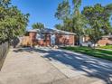 A charming brick home featuring a wide driveway, well-maintained lawn, and a secure wooden fence at 1731 Uinta St, Denver, CO 80220