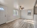 Bright living room with wood-look floors, a ceiling fan, and natural light from windows at 1731 Uinta St, Denver, CO 80220