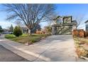 Home's driveway flanked by mature trees and green lawn at 12734 Eudora Dr, Thornton, CO 80241