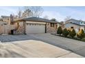 Brick home boasting a long driveway and tidy front yard with small, sculpted trees at 13215 Peacock Dr, Lone Tree, CO 80124