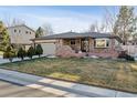 Inviting brick home with a lush green lawn and well-manicured landscaping at 13215 Peacock Dr, Lone Tree, CO 80124