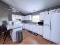 Well-lit kitchen with stainless steel appliances, white cabinetry, and breakfast bar with stools at 30819 Hilltop Dr, Evergreen, CO 80439