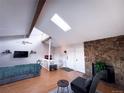 Spacious living room with wood burning fireplace, skylight, and neutral decor at 30819 Hilltop Dr, Evergreen, CO 80439