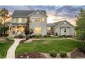 Attractive two-story home showcasing manicured lawn, mulched flower beds, and neutral gray facade on a partly cloudy day at 5397 Lenox Ct, Castle Rock, CO 80104
