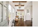 Bright foyer featuring dark hardwood floors, wood beam ceilings, an elegant light fixture, and large picture windows at 5397 Lenox Ct, Castle Rock, CO 80104