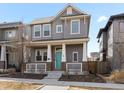 Charming two-story home with a welcoming front porch and a bright blue front door at 10000 E 59Th Dr, Denver, CO 80238