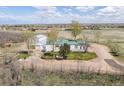 Expansive aerial view of a white home with outbuildings on a large rural lot at 17445 County Road 6, Brighton, CO 80603