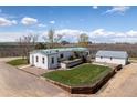 Well-maintained backyard featuring a deck, fenced garden area, and detached garage at 17445 County Road 6, Brighton, CO 80603