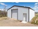 White barn with metal siding and roll-up door, providing ample storage space at 17445 County Road 6, Brighton, CO 80603