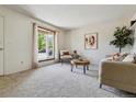 Inviting living room featuring a large bay window, plush carpet, and modern décor at 8625 W Dartmouth Pl, Lakewood, CO 80227