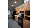 Kitchen features orange cabinets, black appliances, and laminate flooring at 440 Empire St, Aurora, CO 80010