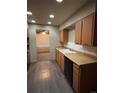 View of kitchen with orange cabinets, black appliances, and laminate flooring at 440 Empire St, Aurora, CO 80010