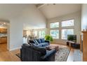 Open-concept living room with hardwood floors and large windows overlooking the backyard at 14261 W Evans Cir, Lakewood, CO 80228