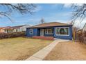 Quaint single-story blue home with a cozy brick porch and mature trees in a quiet neighborhood at 2281 Florence St, Aurora, CO 80010