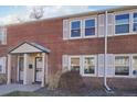 Red brick townhouse featuring symmetrical windows, white shutters, and a covered entry porch at 2805 Jasmine St, Denver, CO 80207