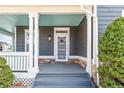 Charming front porch featuring stone accents, gray steps, and a decorative white storm door at 5140 Mt Pawnee Ave, Frederick, CO 80504