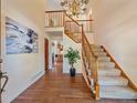 Spacious foyer features wood floors, a staircase with carpet runner, and elegant chandelier lighting at 4228 Scenic Village Dr, Evergreen, CO 80439