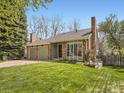 Charming single-story home features brick accents, a lawn, and a two-car garage at 7872 S Hill Dr, Littleton, CO 80120