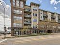 Multi-story condo with brick and stucco facade, balconies, and first-floor commercial space at 1441 Central St # 203, Denver, CO 80211