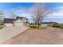 Wide driveway leading to a charming home with a large garage and a spacious outbuilding at 29145 E 160Th Ct, Brighton, CO 80603