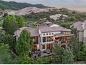 Stone home featuring a large outdoor patio, balcony, and views of the surrounding mountain landscape at 7208 Raphael Ln, Littleton, CO 80125