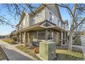 View of a stucco-clad townhouse with stone accents and a tiled roof, nestled within a residential neighborhood at 22520 E Ontario Dr # 101, Aurora, CO 80016