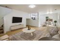 Bright living room with modern furniture, light hardwood floors, and access to the dining room at 5225 E 100Th Dr, Thornton, CO 80229