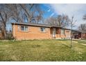 Charming brick home with a well-maintained lawn and attached garage at 3937 W Grand Ave, Littleton, CO 80123