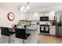 Modern kitchen with granite countertops, stainless steel appliances, breakfast bar with seating, and neutral backsplash at 601 W 11Th Ave # 409, Denver, CO 80204