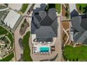 This aerial view shows a home with a swimming pool, lounge chairs, and lush landscaping at 5625 Heritage Oak Dr, Parker, CO 80134