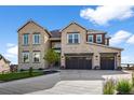 This well-manicured front exterior boasts a three-car garage and classic stone facade at 5625 Heritage Oak Dr, Parker, CO 80134