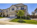 Charming two-story home with a well-manicured lawn, inviting front porch, and attached garage at 14437 Grape St, Thornton, CO 80602