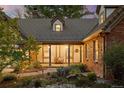 Inviting covered front porch with a wooden bench and stone pathway surrounded by lush landscaping and charming exterior lights at 6248 S Coventry Ln, Littleton, CO 80123