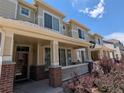 Charming townhome exterior with a covered front porch and well-maintained landscaping at 16051 E Geddes Dr # 66, Aurora, CO 80016