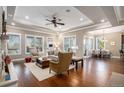 Bright living room featuring hardwood floors, large windows, and an open layout connecting to the dining area at 2091 Ramblewood Ct, Castle Rock, CO 80104