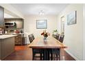 Dining room with hardwood floors adjacent to a kitchen area featuring updated cabinetry at 2306 S Troy St # A, Aurora, CO 80014