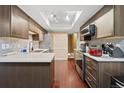 Modern kitchen featuring stainless steel appliances, stone countertops, hardwood floors, and under cabinet lighting at 2306 S Troy St # A, Aurora, CO 80014