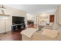 Inviting living room with hardwood floors, comfy couch, entertainment center, and open layout to the dining area at 2306 S Troy St # A, Aurora, CO 80014