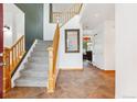 Welcoming foyer featuring tile floors, wooden staircase, and an open floorplan at 5282 Devon Ave, Castle Rock, CO 80104