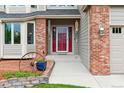 Close up of the entryway with red door, brick accents, and attractive wall decor at 5282 Devon Ave, Castle Rock, CO 80104