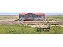 Exterior view of home with covered porch and well-maintained landscaping at 41575 E 88Th Ave, Bennett, CO 80102