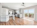 Bright, modern kitchen with stainless steel appliances, light gray cabinets, and wood flooring at 41575 E 88Th Ave, Bennett, CO 80102