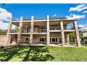 Beautiful backyard with multiple levels of balconies with brick supports and lush green grass at 2595 S Harlan Ct, Lakewood, CO 80227